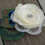 Bridal ivory satin lace flower hair clip accented with a rhinestone, peacock eye and sward feathers