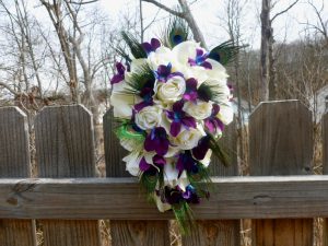 Silk rose and galaxy orchid bridal bouquet with peacock feathers