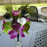 Cymbidium orchid and calla lily bouquet with peacock feathers
